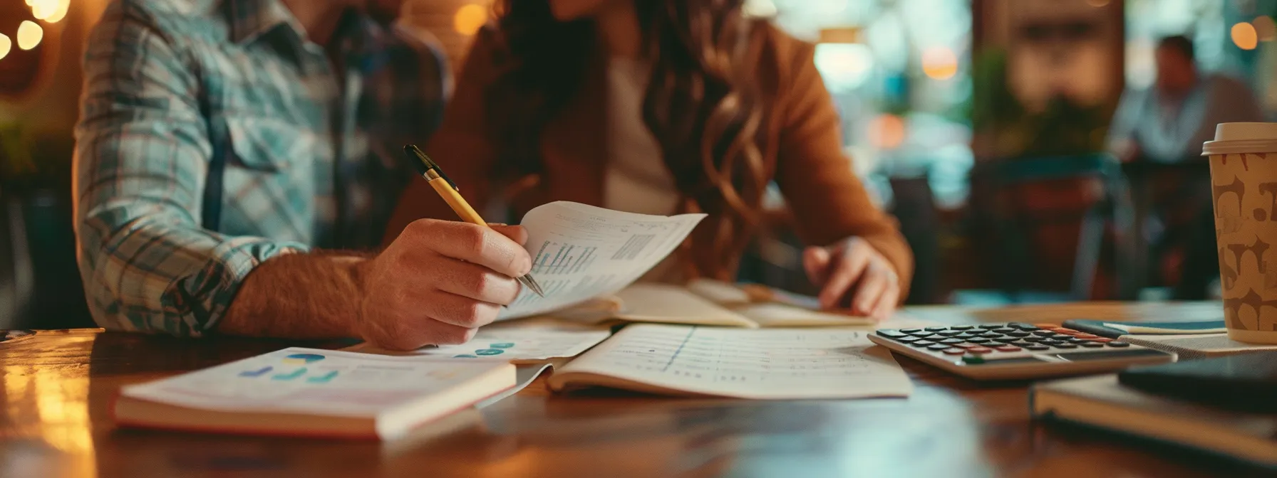 a couple reviewing their credit score and financial documents together at a cozy miami coffee shop, with calculators and notebooks spread out on the table.