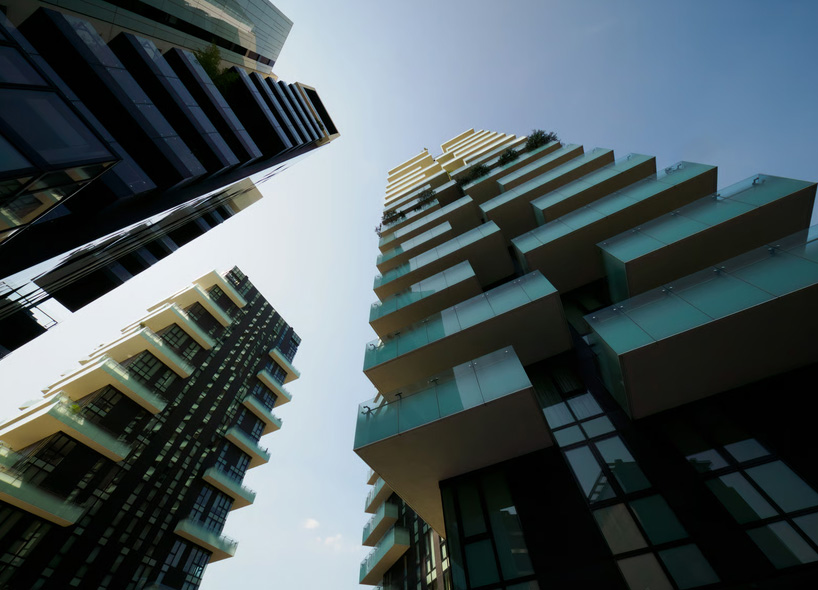 An extreme upward-angle shot in a dense urban environment, showcasing a lush vertical-garden building labeled 'THE URBAN OASIS - PRE-CONSTRUCTION PHASE' adjacent to a modern dark tower with a sign that reads 'RESALE UNIT AVAILABLE'. A 'Lending Bankers Mortgage' logo is integrated at the base of the resale building.