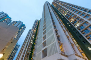 Low-angle exterior view of tall residential high-rise condotel buildings in an urban setting.